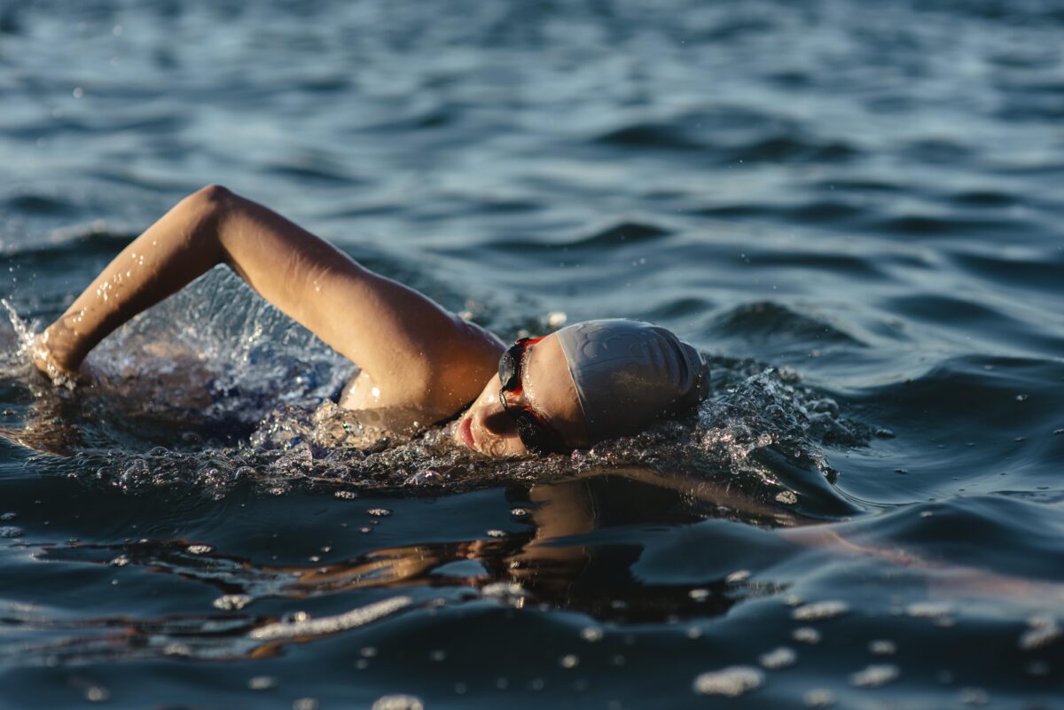 side-view-female-swimmer-with-cap-goggles-swimming-water-1-1200x801.jpg